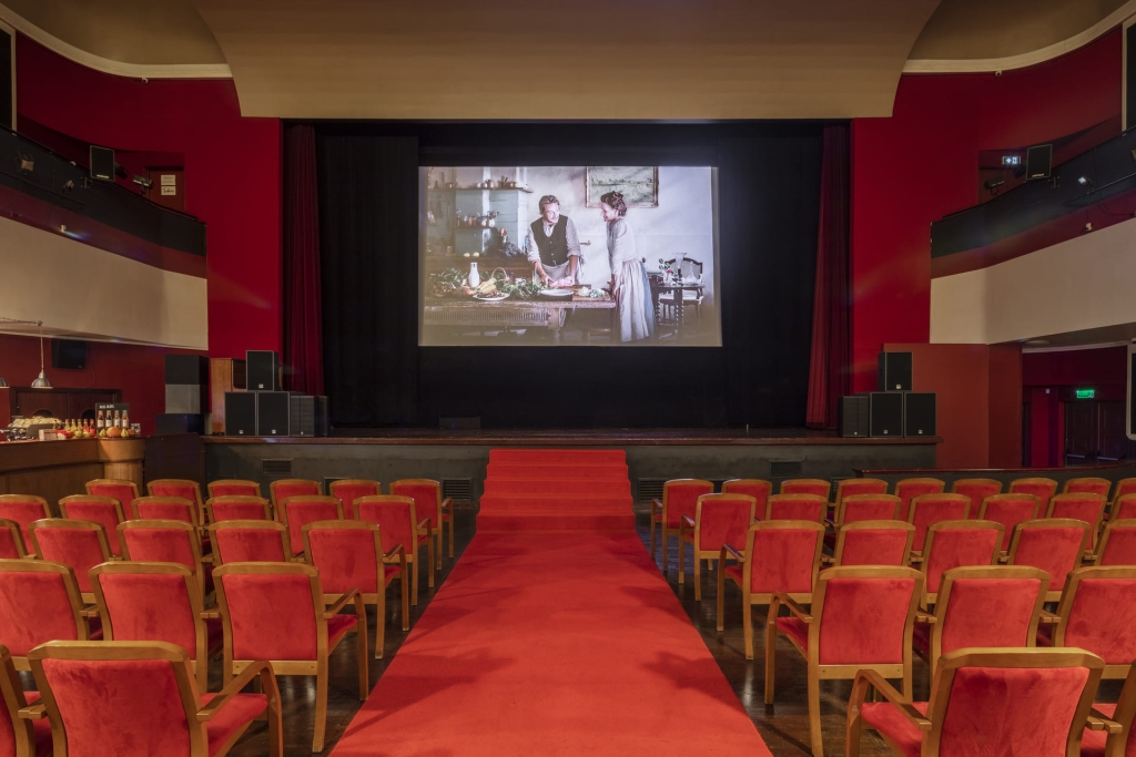 Sala kinowa z krzesłami i ekranem na środku