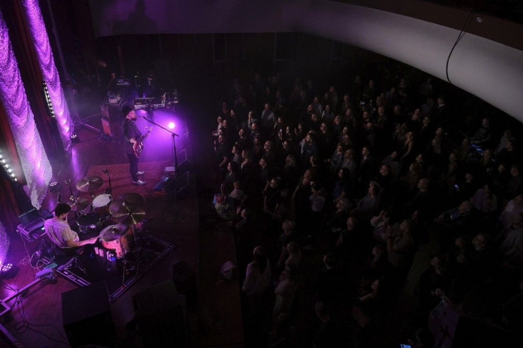 Koncert muzyczny na środku sceny zespół na widowni tłum ludzi